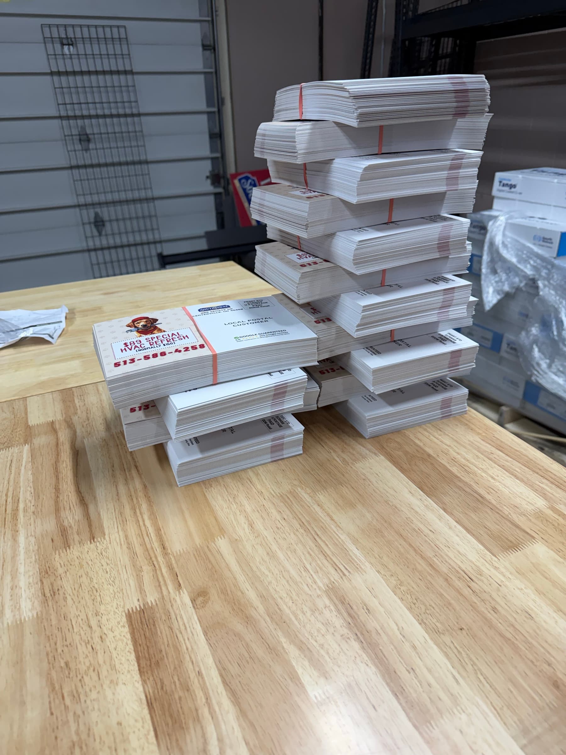 Banded bundles of finished postcards stacked on the work table