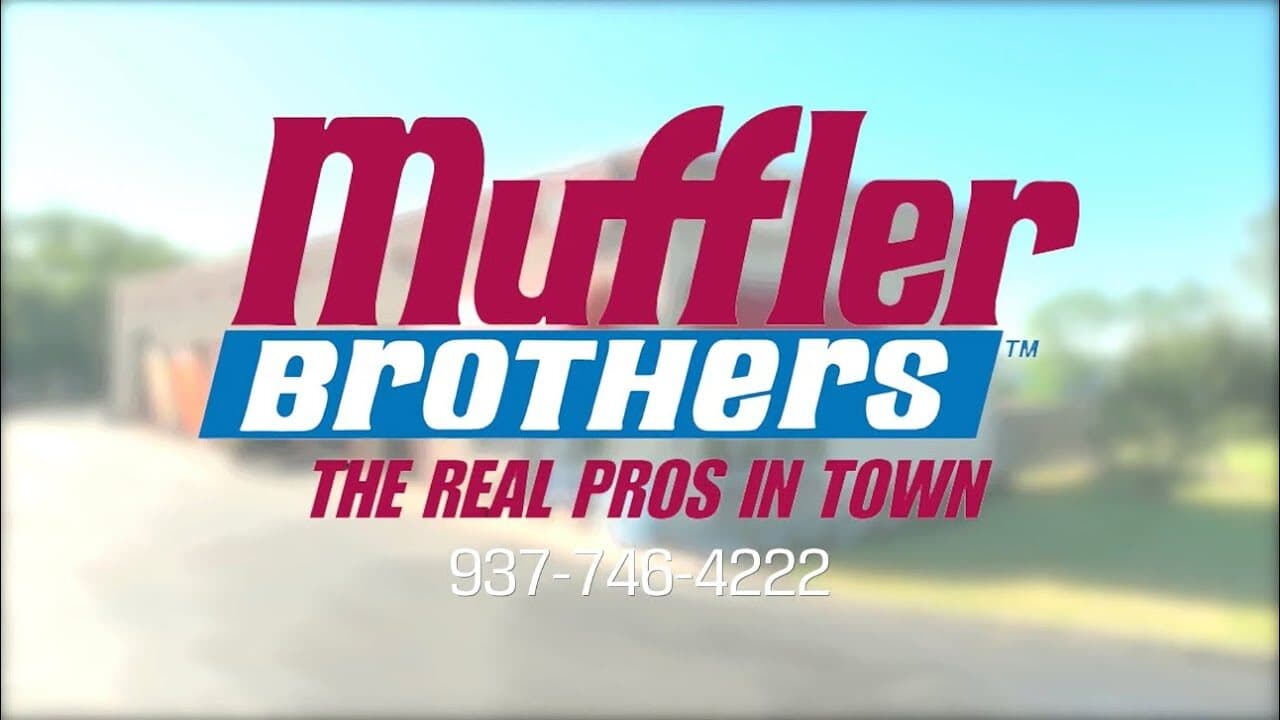 The Muffler Brothers logo, "The real pros in town", over a blurred building and trees